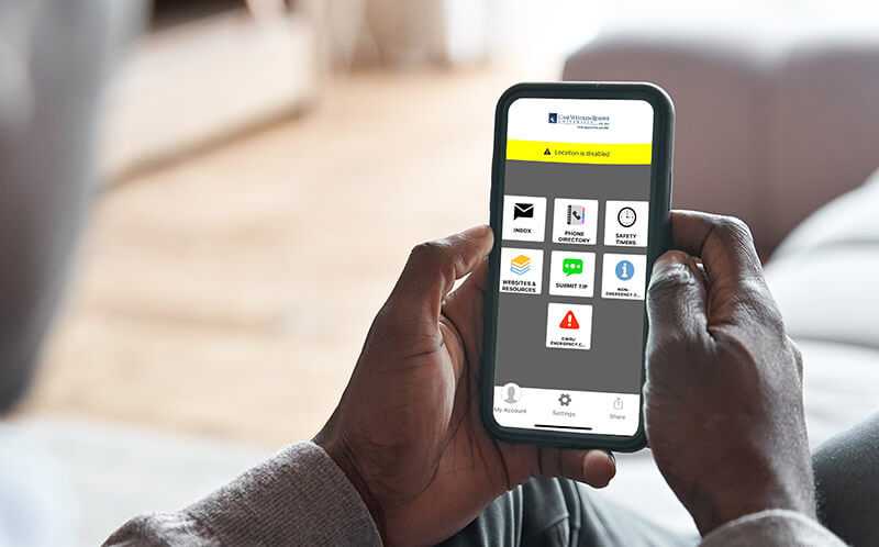 Photo of a person’s hands holding a smartphone with the Rave Guardian app open